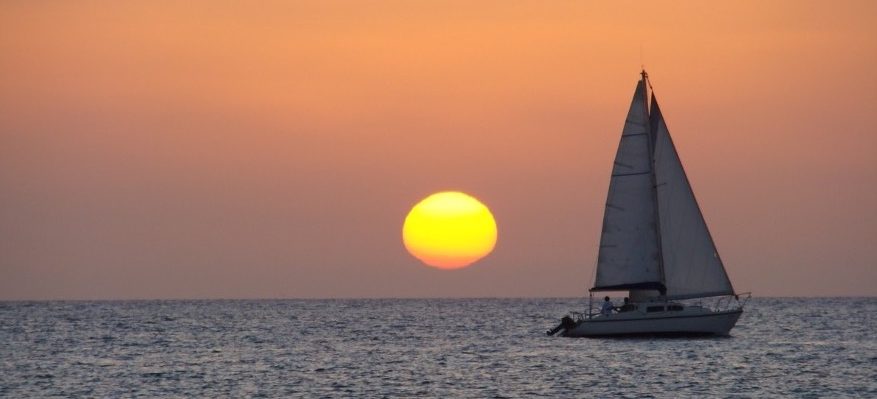 Barco de vela navegando por el mar al atardecer